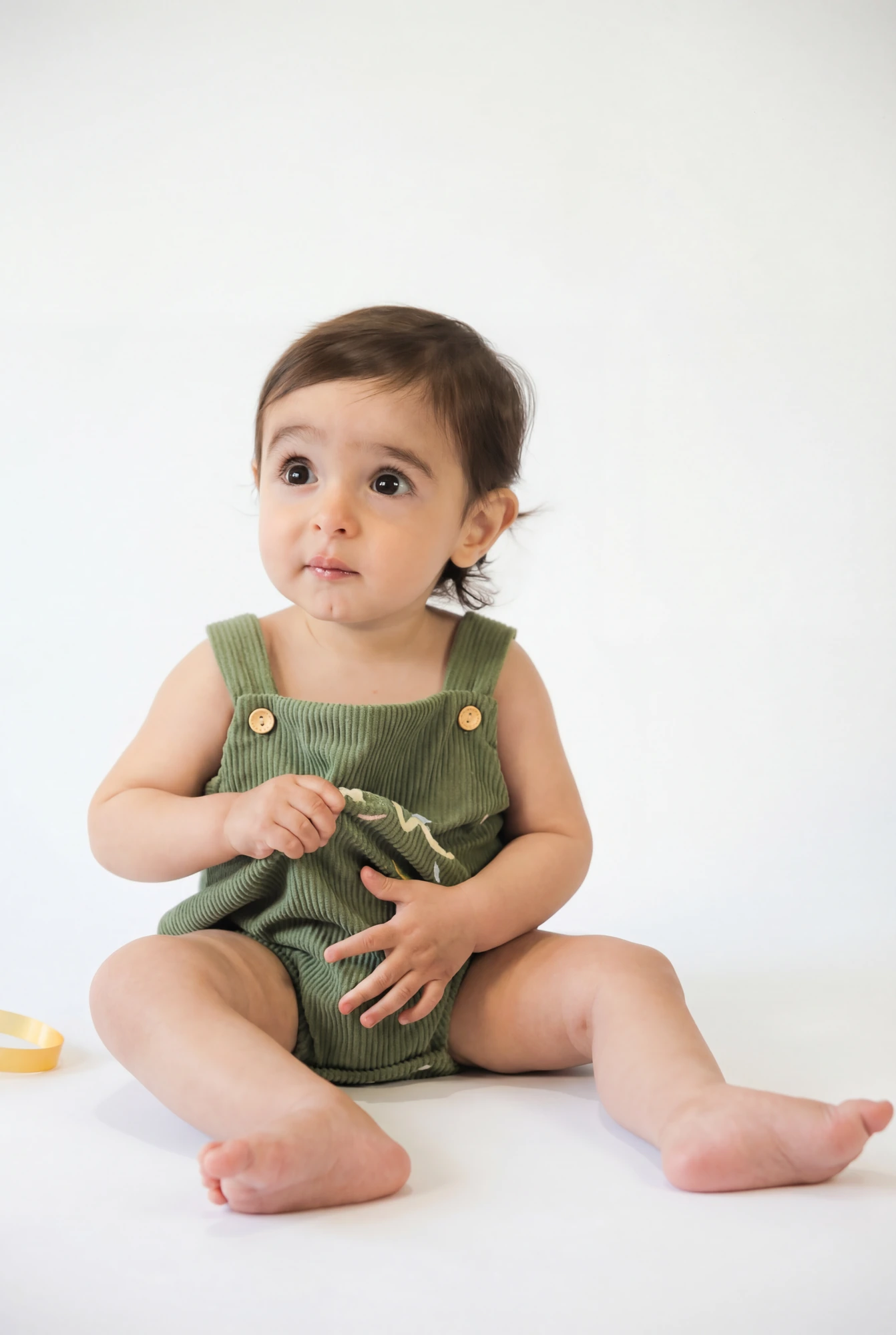 Niño sentado con un peto verde